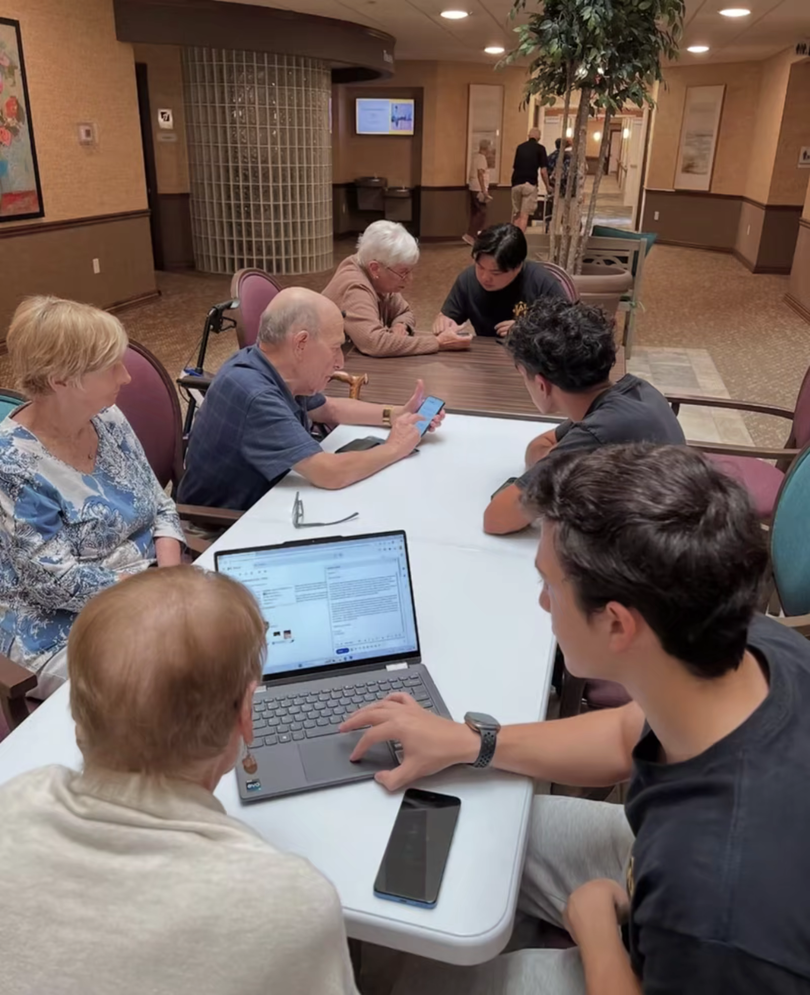 Student volunteer helping a senior with technology